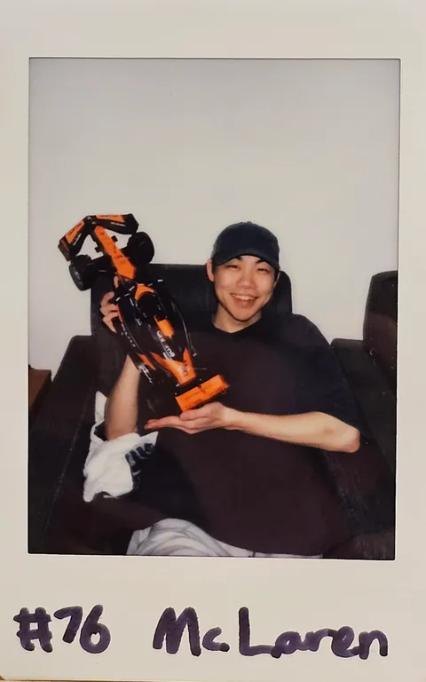 A Polaroid of Ben holding a McLaren model
